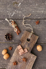 Pieces of chocolate, cinnamon sticks and star anise on a wooden board. High quality photo