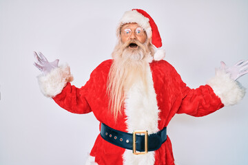 Old senior man with grey hair and long beard wearing santa claus costume celebrating victory with happy smile and winner expression with raised hands