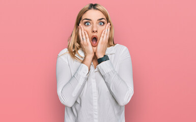 Young caucasian woman wearing casual clothes afraid and shocked, surprise and amazed expression with hands on face