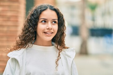 Hispanic teenager girl smiling happy standing at the city.