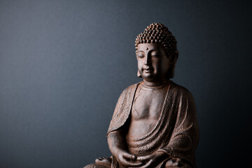 Meditating Buddha Statue on paper background. Copy space.