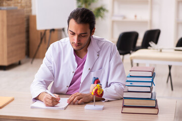 Young male doctor student cardiologist sitting in the classroom