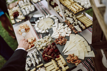 hand picking cheese from a cheese board in a wedding cocktail