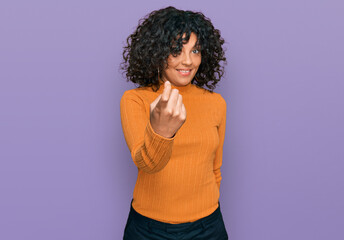 Young hispanic woman wearing casual clothes beckoning come here gesture with hand inviting welcoming happy and smiling