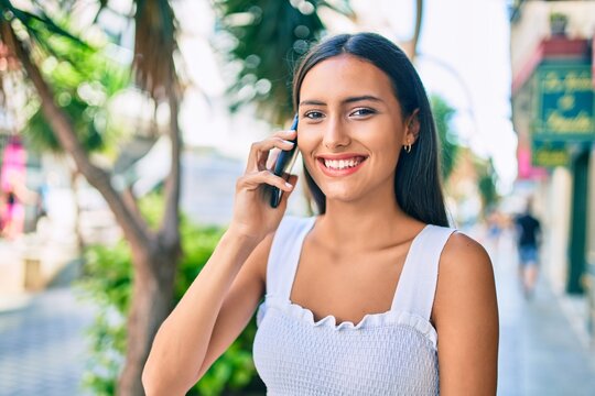 Young latin girl smiling happy talking on the smartphone at street of city.
