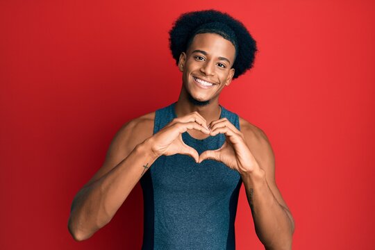 African american man with afro hair wearing sportswear smiling in love showing heart symbol and shape with hands. romantic concept.