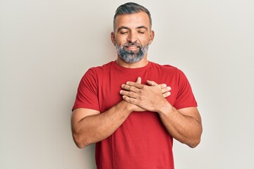 Middle age handsome man wearing casual clothes smiling with hands on chest, eyes closed with grateful gesture on face. health concept.