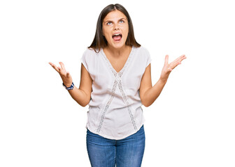 Young caucasian woman wearing casual clothes crazy and mad shouting and yelling with aggressive expression and arms raised. frustration concept.