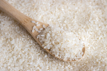 白米の背景と、木のスプーン