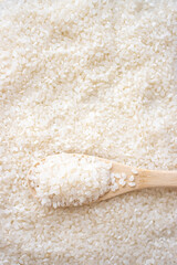 白米の背景と、木のスプーン