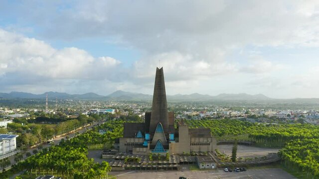 The famous Catedral Bas&iacute;lica de Nuestra Se&ntilde;ora de la Altagracia aerial view. Panorama of the city of Higuey against the backdrop of a mountain range and blue cloudy sky. Beautiful cityscape.