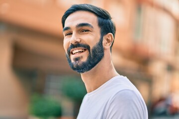 Obraz premium Young hispanic man smiling happy standing at the city.