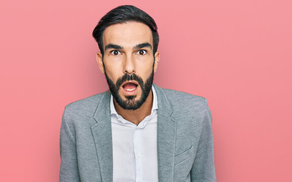 Young hispanic man wearing business clothes afraid and shocked with surprise and amazed expression, fear and excited face.