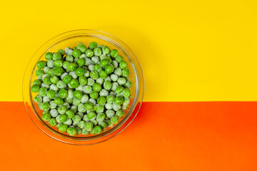 bowl with frozen peas on orange and yellow background