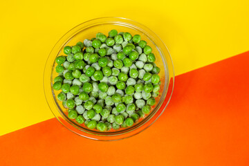 bowl with frozen peas on orange and yellow background