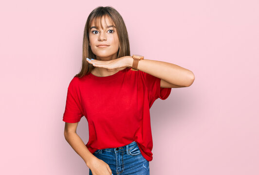 Teenager caucasian girl wearing casual red t shirt cutting throat with hand as knife, threaten aggression with furious violence
