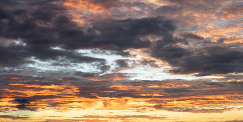 Orange colored sky with dramatic dark clouds