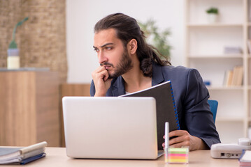 Young male employee working in the office