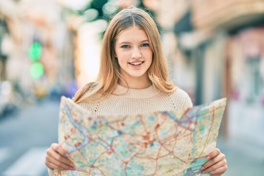Beautiful caucasian tourist teenager smiling happy holding map at the city.