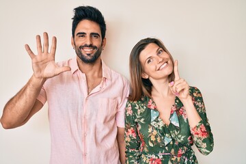 Beautiful young couple of boyfriend and girlfriend together showing and pointing up with fingers number six while smiling confident and happy.
