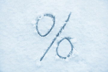 Percent sign written on a snow. Abstract symbol.
