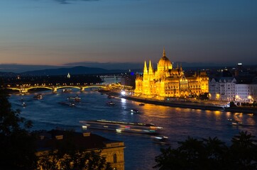 Obraz premium Night view of illuminated beautiful Parliament building across river Danube in Budapest, Hungary