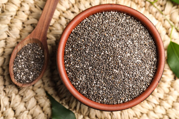 Bowl and spoon with chia seeds on wicker stand, flat lay