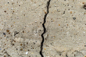 Rough textured surface of cracked concrete foundation slab.