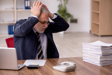 Aged male employee unhappy with excessive work in the office