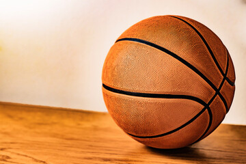 balon de basketball en piso de madera con fondo claro 
