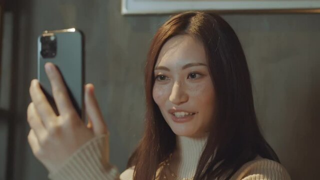 Close shot of asian young woman talking on smartphone. 