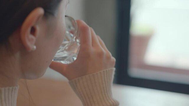 Young asian woman drinking water in a cafe 4K