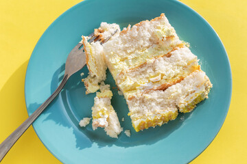 Blue plate with cake on yellow background. Slice of banana cake with fork on blue plate.