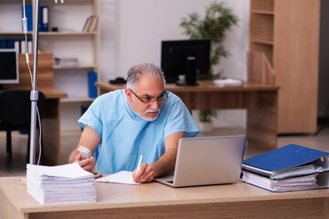 Old male employee in blood transfusion concept