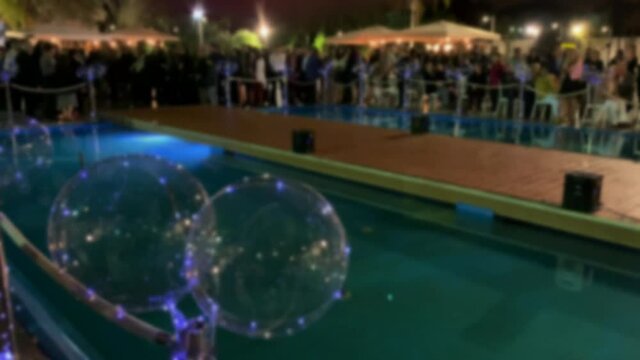 Guests await the start of a Jewish wedding ceremony with a chuppah. Blurred view. 4K