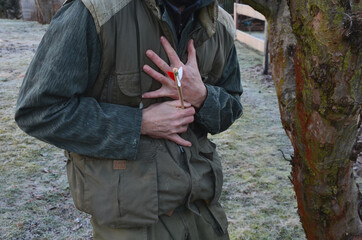 A man in green clothes is hit by an arrow. falls to the ground. holding an arrow stuck in his body....