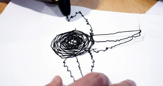 Man 3d pen draws a flower on white paper close-up
