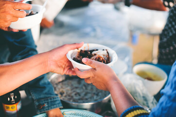Volunteers donating food to people in a society in need of food: the concept of helping with food.