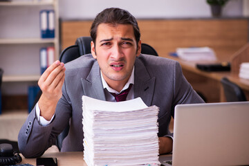 Young male employee extremely tired with excessive work