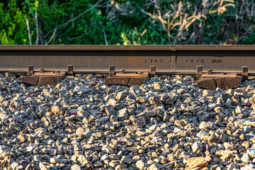 Closeup of railroad track rolled in June of 1970 (six tic marks = month) still serving the rail line on its stone bed.