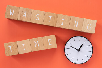 時間の無駄｜「WASTING TIME」と書かれた積み木と時計