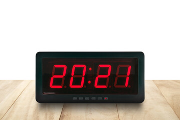 numbers 2021 on digital alarm clock face on wooden table isolated on white background