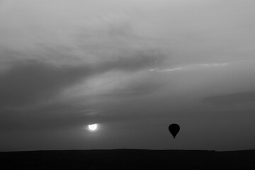 Hot air balloons over the rocks on sunrise with empty blue sky