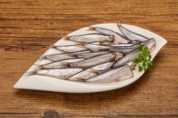 Anchovies in the bowl served basil leaves