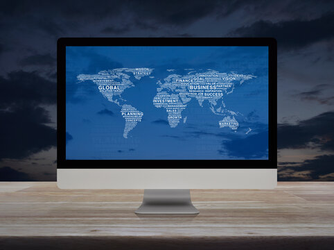 Global business words world map on desktop modern computer monitor screen on wooden table over sunset sky, Global business online concept, Elements of this image furnished by NASA