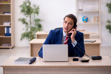 Young male employee sitting in the office