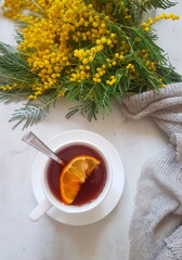 tea with lemon and a bouquet of mimosa