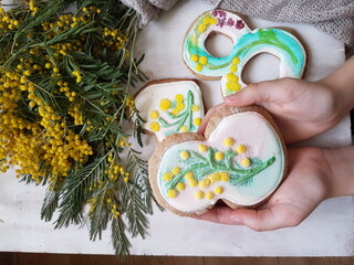 Children's hands hold a glazed gingerbread