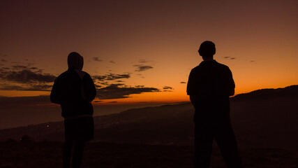 silueta de gente con vistas y puesta del sol