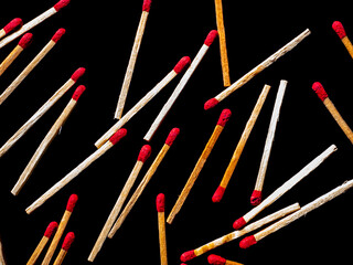Wooden matches with red sulfur heads on a black background. Fire ignition matches. Matchbox. Red...